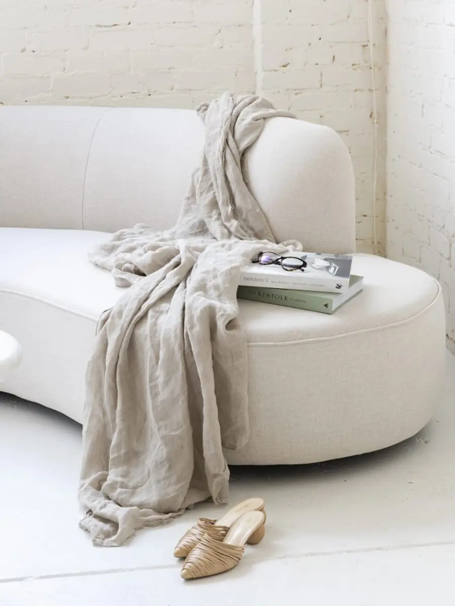 Minimal living room with curved sofa and linen throw, residential interior Mumbai